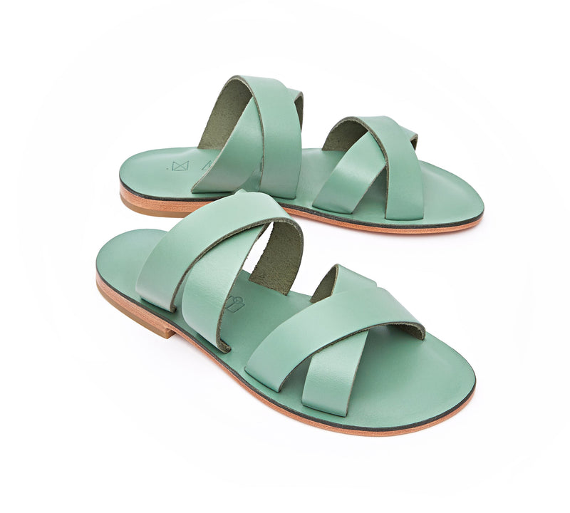 Angled view of the handmade Wave women's slip-on leather sandals in light green / GREEN