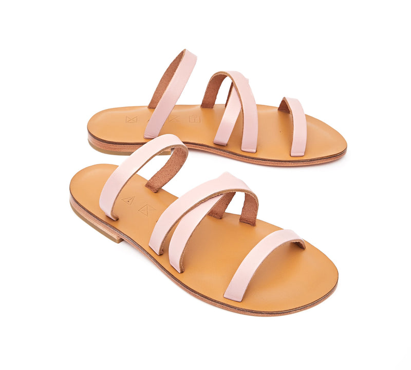 Angled view of the handmade Wind women's slip-on leather sandals in natural tan insole with light pink straps / PINK