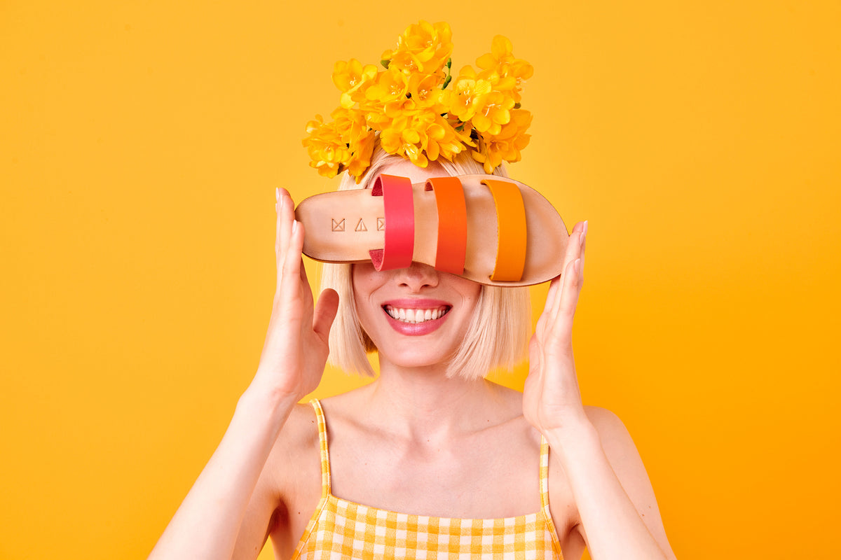 Maki Sandals in sunset colours covering the eyes of the happy model.