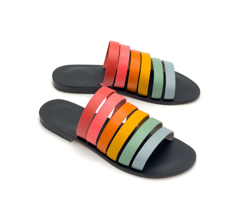 Angled view of the handmade Sunshine women's slip-on leather sandals in black insole with rainbow straps / RAINBOW