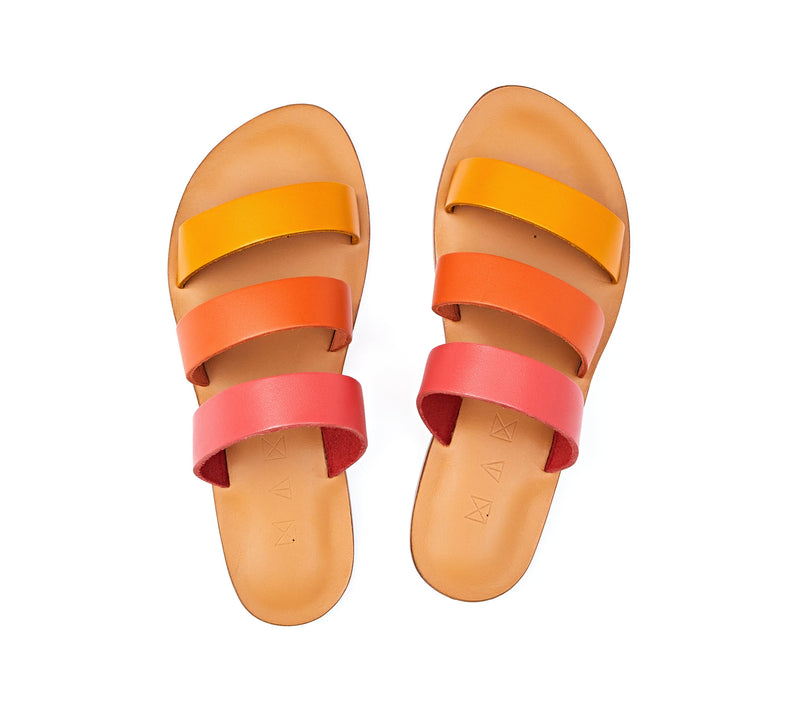 Top view of the handmade Sky women's slip-on leather sandals in natural tan insole with pomegranate, orange and yellow straps / SUNSET