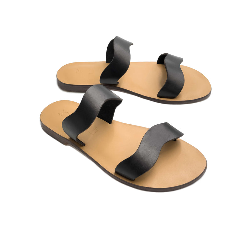 Angled view of the handmade Mare women's slip-on leather sandals with tan insoles and black straps / BLACK