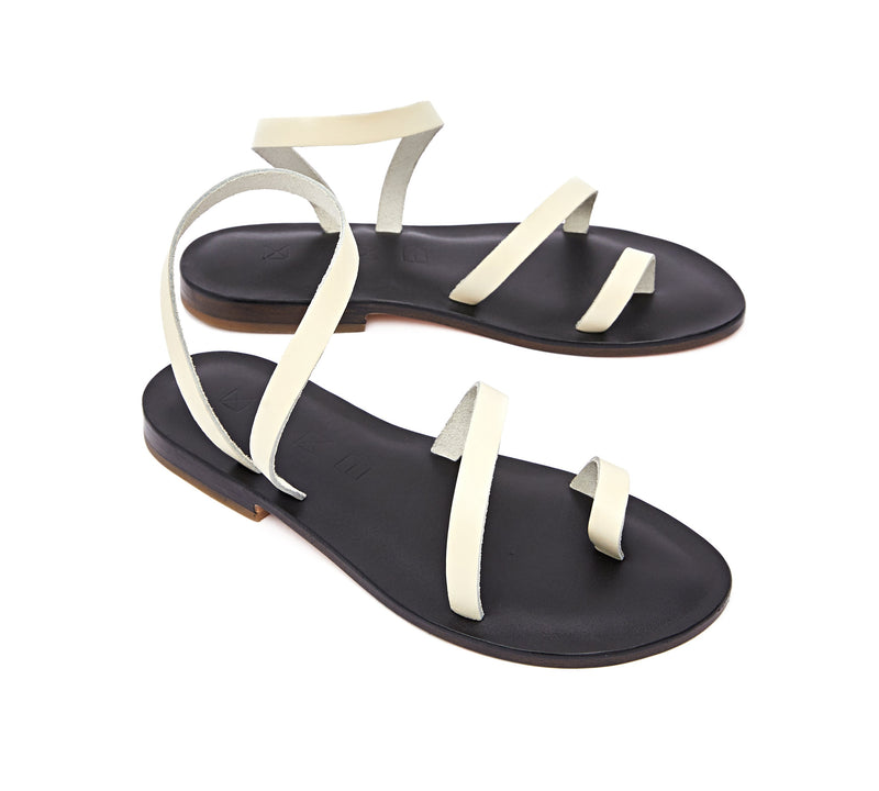 Angled view of the handmade Moon women's slingback leather sandals in black insole with cream straps / CREAM BLACK