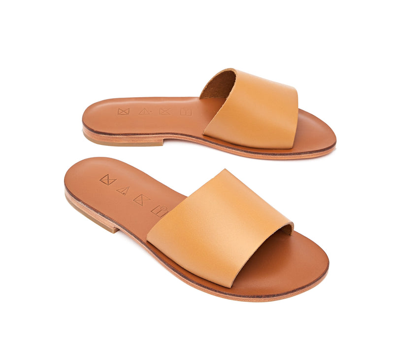 Angled view of the handmade Rock women's slip-on leather sandals in light brown insole with natural tan straps / TAN