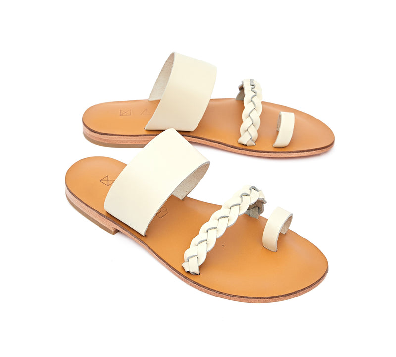 Angled view of the handmade Salt women's braided slip-on leather sandals in natural tan insole with cream straps / CREAM
