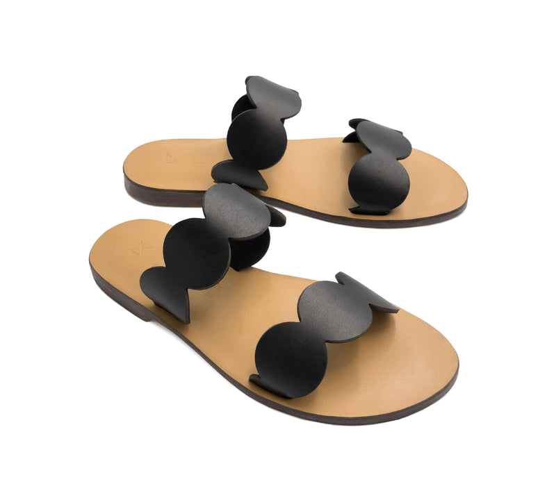 Angled view of the handmade Sol women's slip-on leather sandals with tan insoles and black straps / BLACK