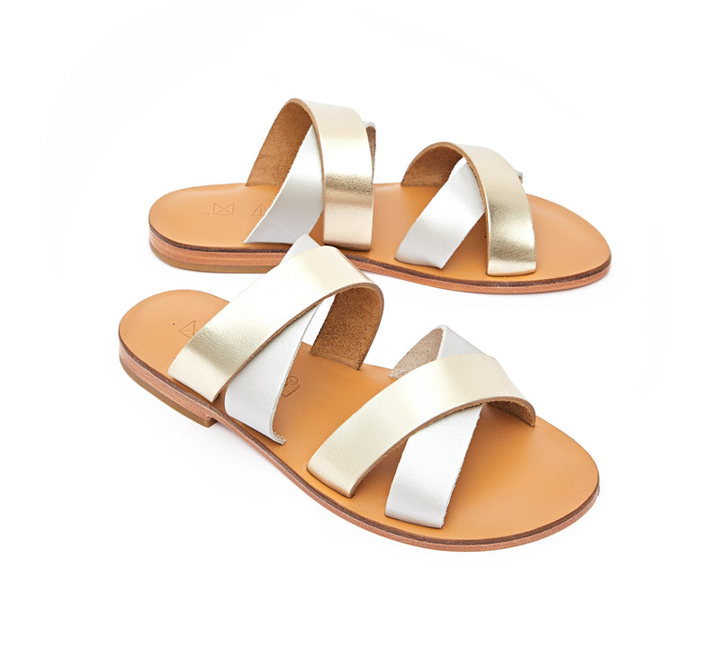 Angled view of the handmade Wave women's slip-on leather sandals in natural tan insole with gold and silver straps / GOLD SILVER