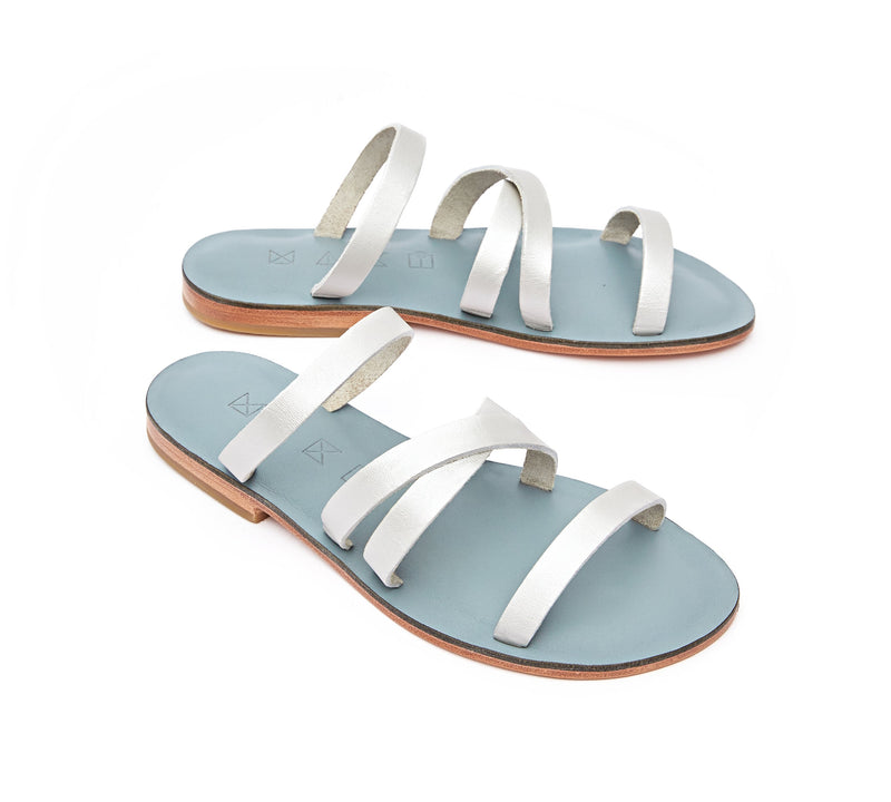 Angled view of the handmade Wind women's slip-on leather sandals in light grey insole with silver straps / SILVER